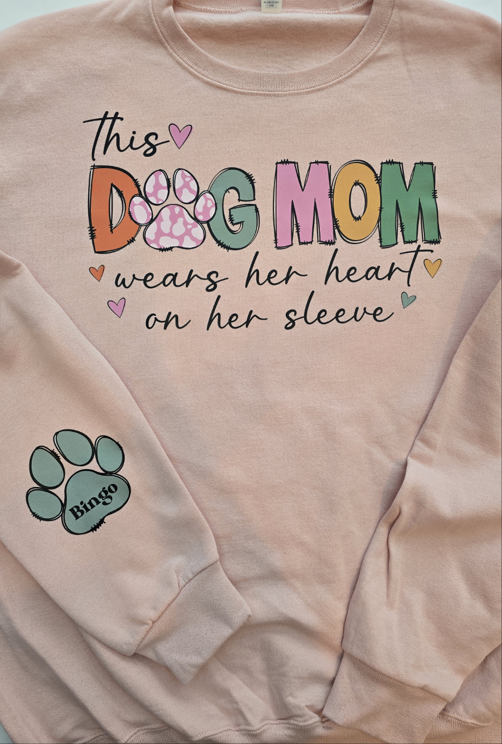 "This Dog Mom Wears Her Heart On Her Sleeve"In BLUSH PINK Personalized Dog Name Sweatshirt in Sweet Cream| Custom Dog Mom Sweatshirt – Personalized Paw Prints & Names