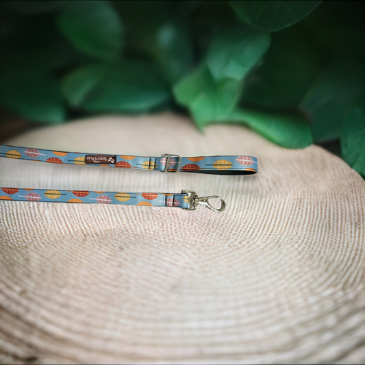 Boho Fall Leaves Dog Leash made from re-purposed bicycle tires, featuring a bottle opener attachment for poop bag holders. Waterproof, naturally antibacterial, and machine washable. Blue leash with fall color leaves