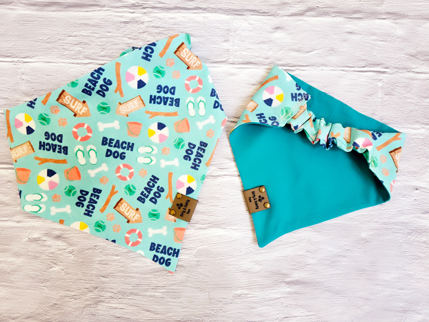 Beach Dog reversible scrunchie bandana with beach-themed design, high-quality materials, and faux leather logo tag, perfect for stylish pups on beach days.