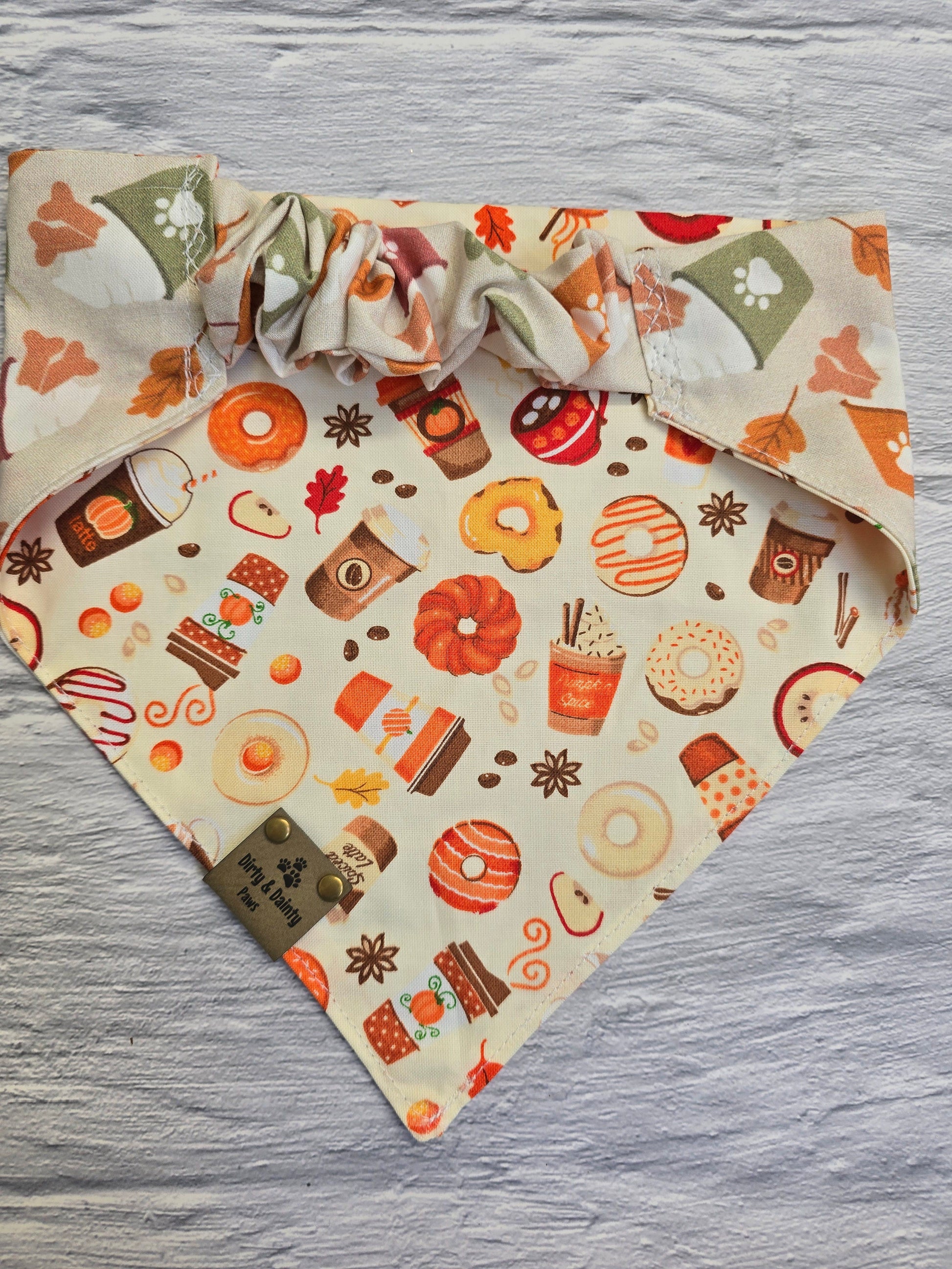 Reversible side of the fall-themed dog bandana showcasing a playful print of autumn treats like donuts, coffee cups, and pumpkin spice lattes.