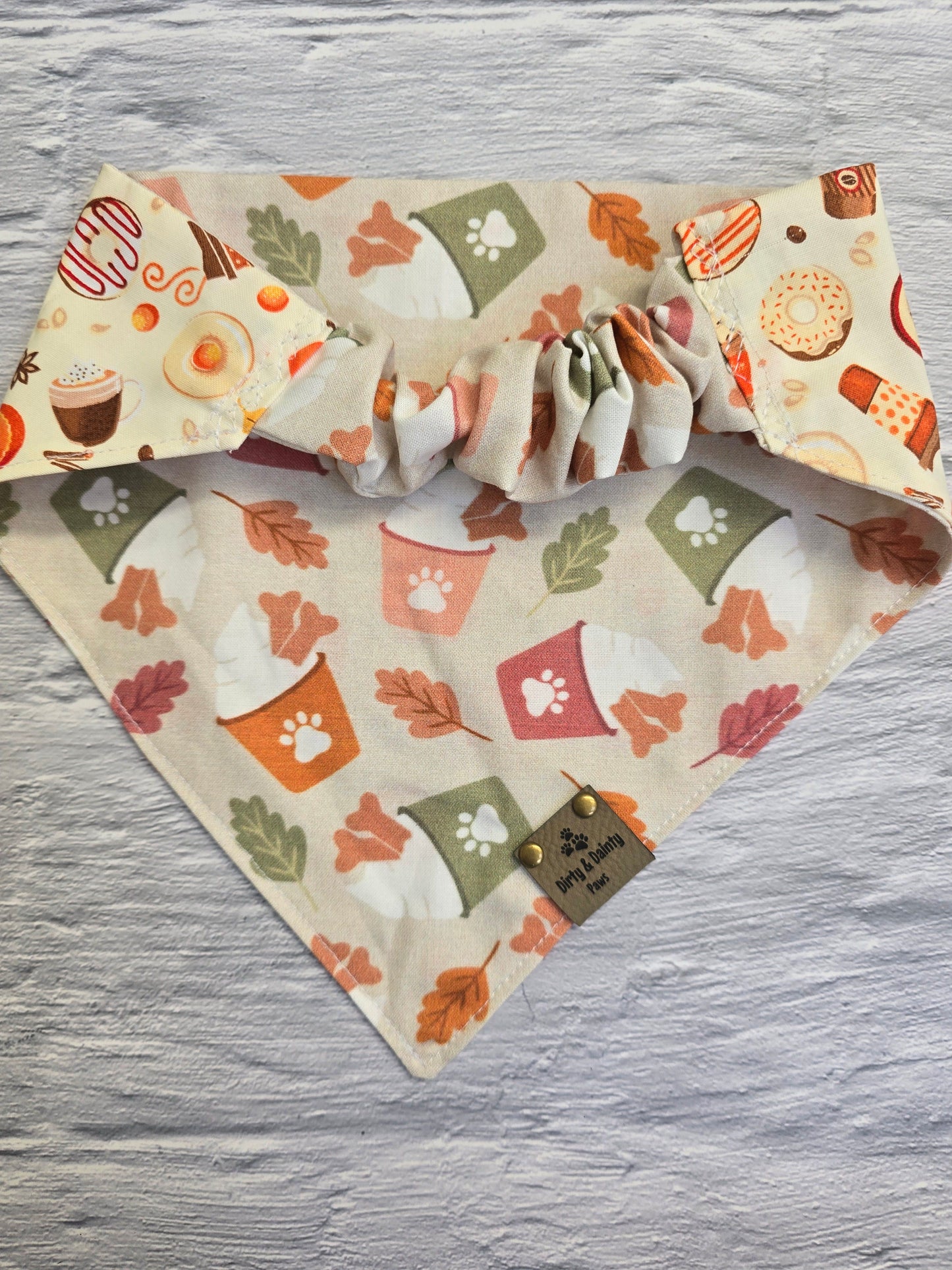 Reversible side of the fall-themed dog bandana showcasing a playful print of autumn treats like donuts, coffee cups, and pumpkin spice lattes.