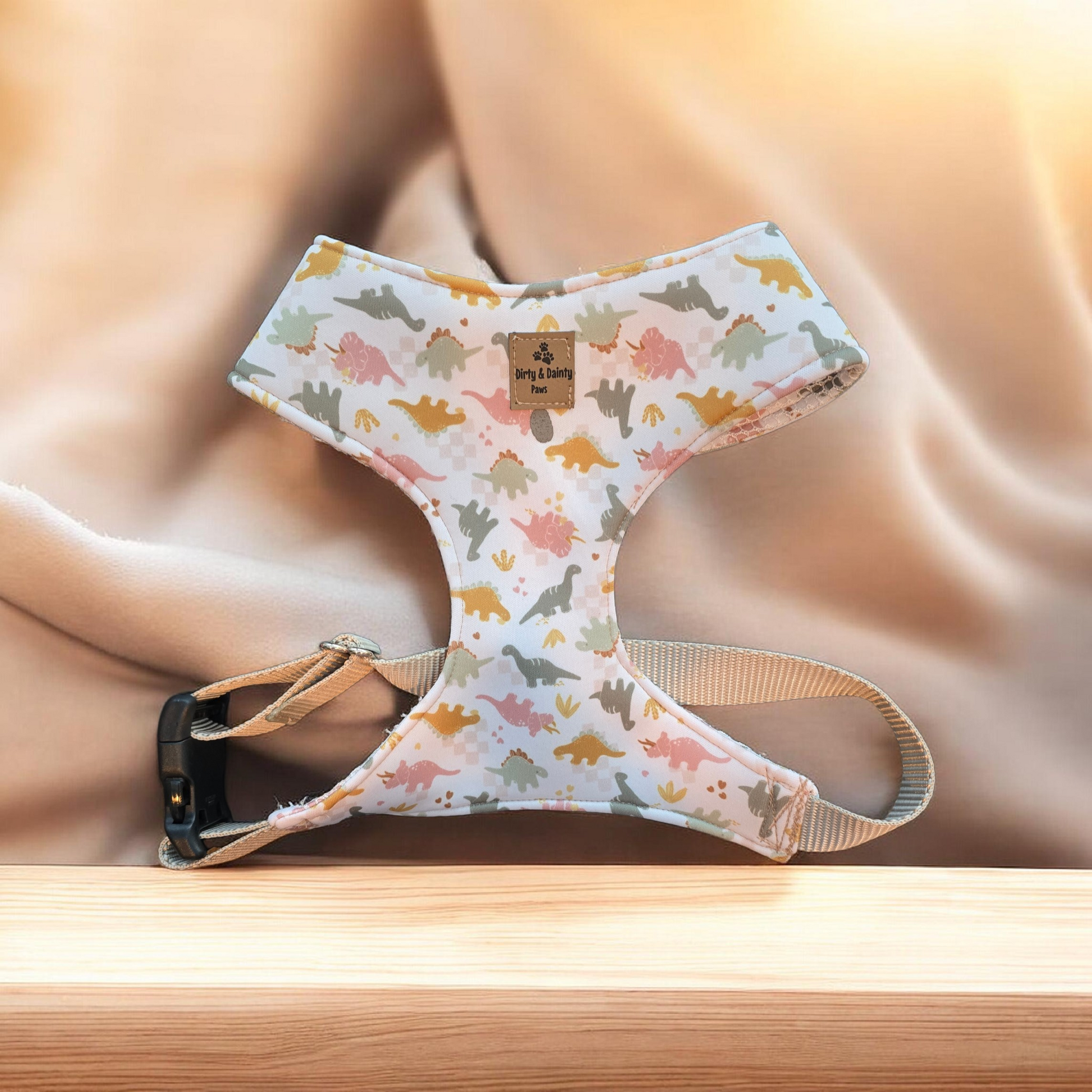 Dog harness with dinosaur pattern on a wooden surface