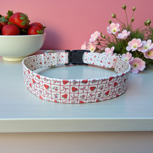 Dog collar with strawberry pattern on a white surface with pink background