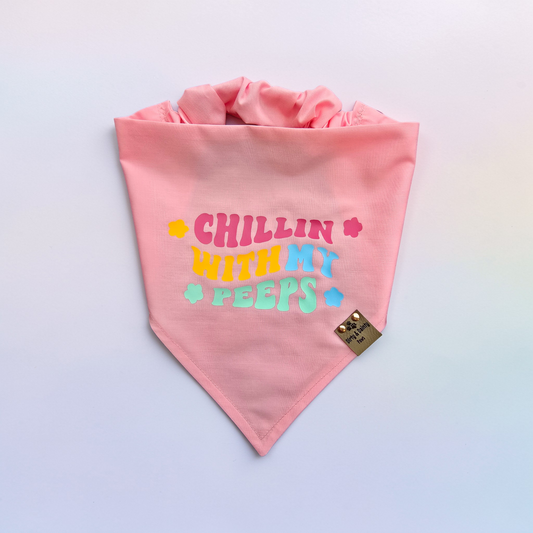 Pink bandana with colorful text that says "Chillin with my peeps"  on a light gray background