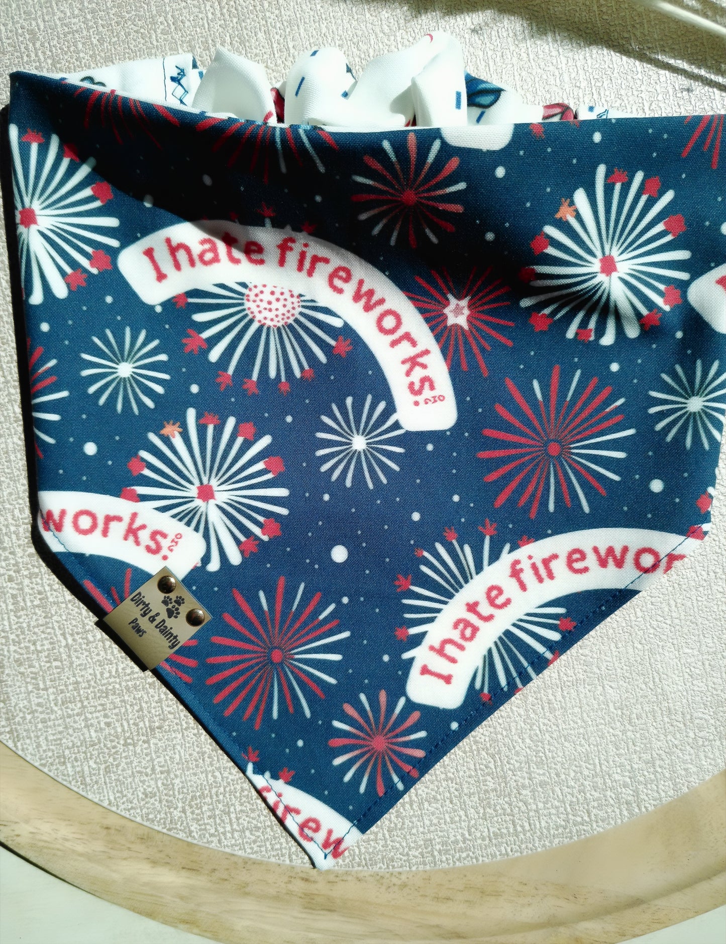 Dog bandana with fireworks and 'I hate fireworks' text on a blue background.