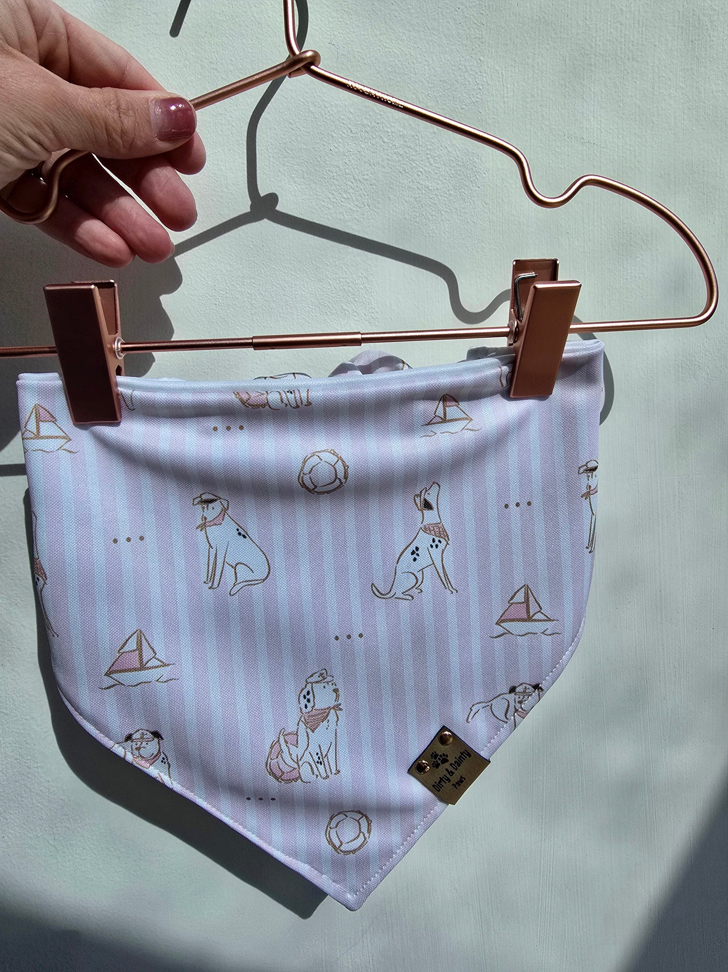 dog bandana with pale pink stripes with preppy coastal dogs and sailboats on it