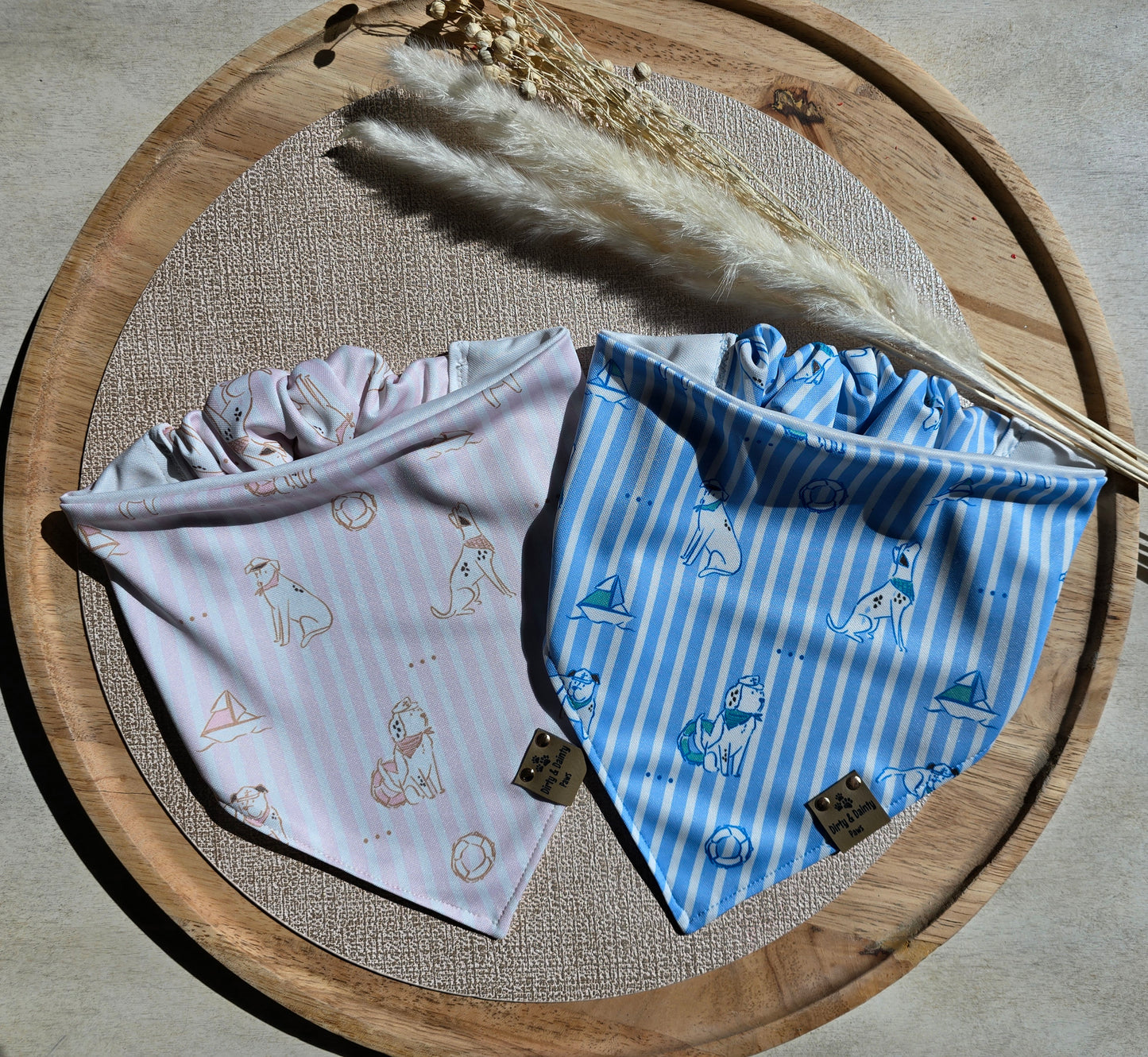 Pink and blue coastal preppy dog bandanas with striped nautical print featuring sailboats, beach balls, and seaside pups. Handmade reversible activewear scrunchie bandanas by Dirty and Dainty Paws