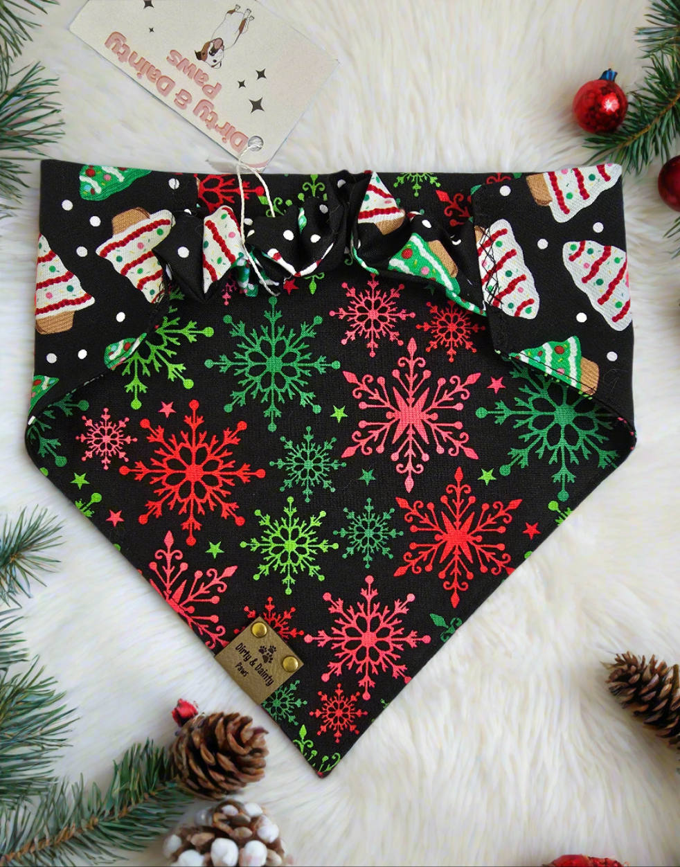 1. Close-up of dog wearing the Christmas Tree / Red & Green Snowflakes reversible scrunchie dog bandana.


2. Christmas tree side of the reversible scrunchie bandana.


3. Red and green snowflake side of the reversible scrunchie bandana.


4. Bandana folded to show both sides of the festive design.


5. Dog wearing the Christmas Tree / Red & Green Snowflakes bandana, showcasing both prints.
