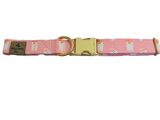 Pink dog collar featuring cute ghosties wearing cowboy hats. The collar includes a gold metal buckle and a Dirty & Dainty Paws branded tag. Ideal for pet owners looking for a stylish and spooky accessory