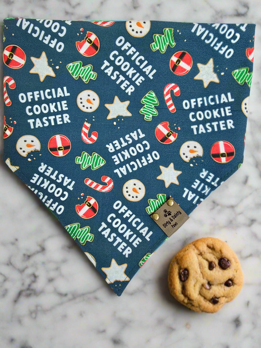 Reversible dog bandana with "Official Cookie Taster" print featuring holiday cookies, candy canes, and Christmas flowers.