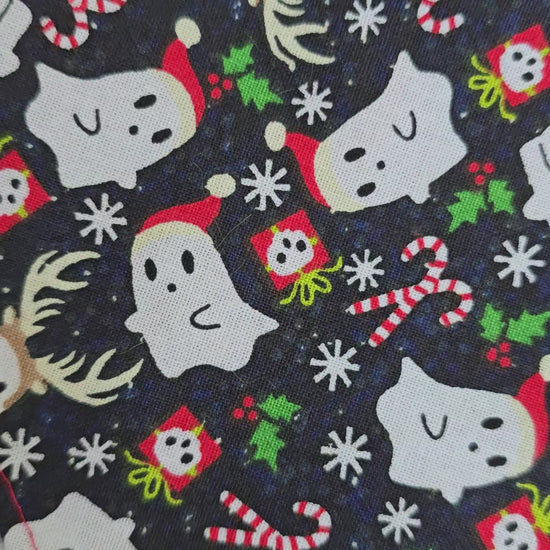 Reversible dog bandana with a "Ghosts of Spooky Christmas" print on one side and a shimmering red plaid design on the other