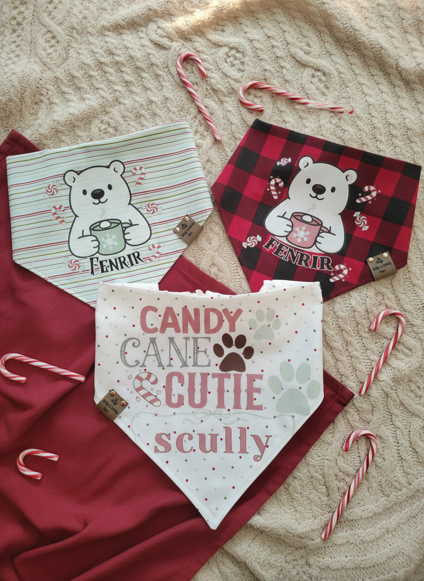Three dog bandanas with bear designs and candy canes on a textured fabric background