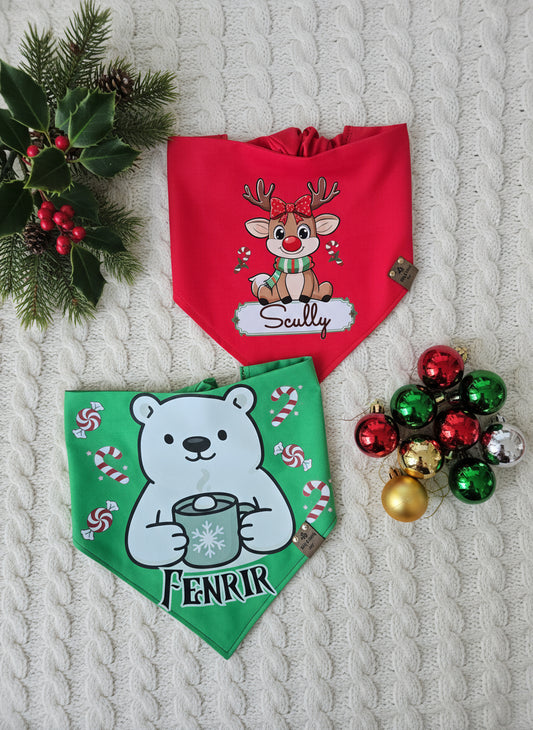 Two dog bandanas with Christmas-themed designs on a textured surface with holiday decorations.