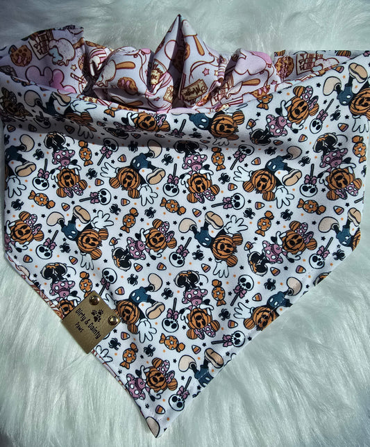Close-up of Magical Treats Disney-inspired mickey and Minnie jack-o-lantern  dog bandana with faux leather Dirty & Dainty Paws tag, made with Zoomie Proof™ polyester fabric.