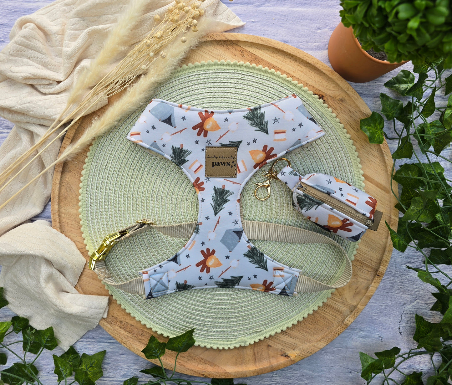 watercolor camping print dog harness with a matching waste bag holder  and plants as decorations