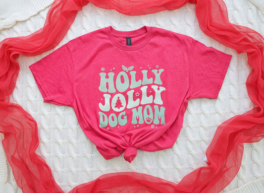 Heather Red t-shirt with 'Holly Jolly Dog Mom' text on a white surface with red fabric.